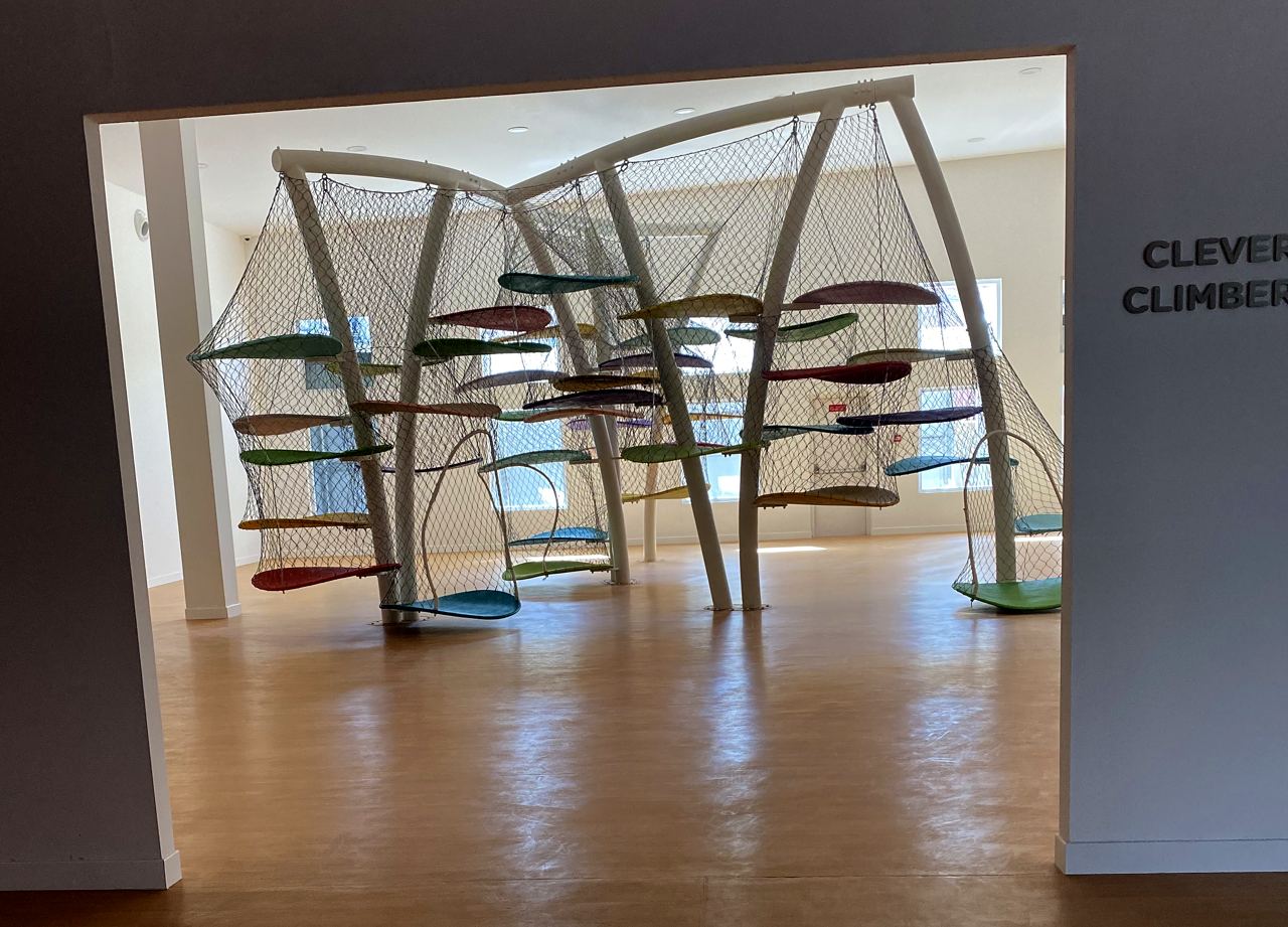 The Clever Climbers gallery, with netted leaf platforms on curved white trees.