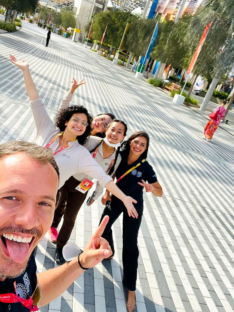 Expo 2020 Dubai team members taking a joyful selfie on the Expo boulevard.