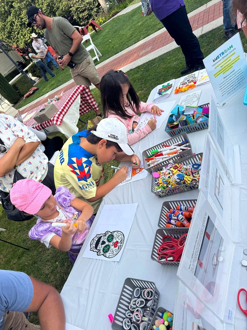 Children colouring and building simple circuits at a Halloween activity table.