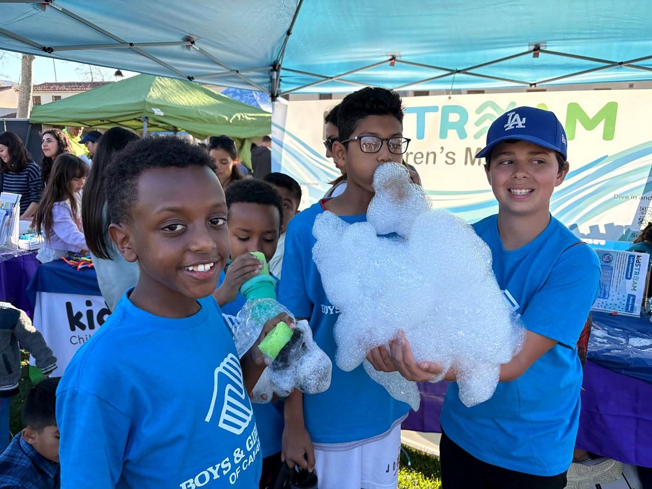 Boys and Girls Club members making giant foam bubble snakes at the kidSTREAM booth.
